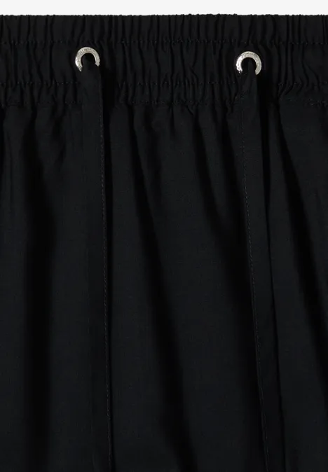 Schwarzer Stoff mit Bund und Kordelzug, einfache Nahteinfassung oben.