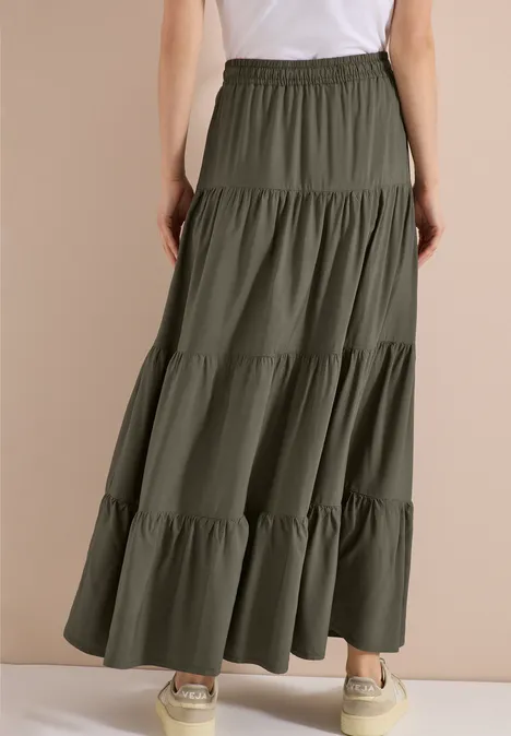 Schlichter olivgrüner Stufen-Maxi-Rock mit Gummibund, kombiniert mit weißen Sneakern.