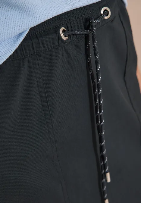 Knielanger Jogg Skirt mit feinen Streifen palm breeze green Detailaufnahme einer schwarzen Hose mit Tunnelzug, Kordel und silbernen Ösen.