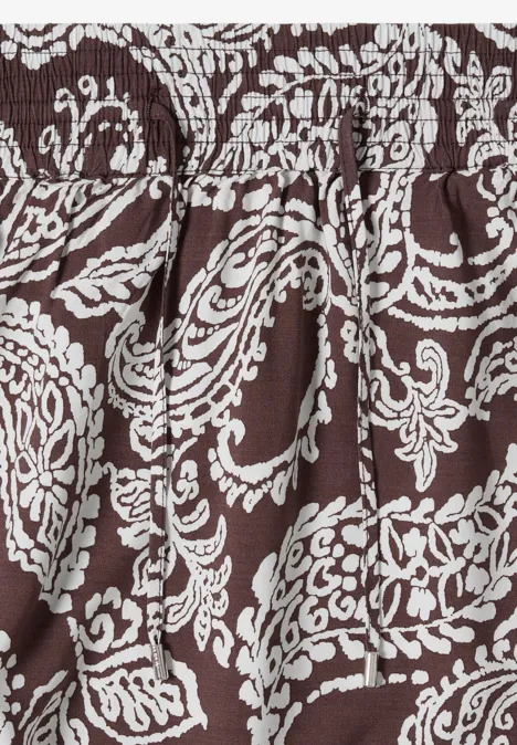 Jupe longue à motifs floraux brown cacao Tissu brun à motifs floraux blancs et plis fluides.