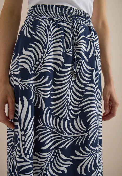 Maxi-Rock mit Blättermuster universal blue Dunkelblauer Rock mit weißem Blattmuster, elastischem Bund und seitlichen Taschen, getragen zu einem weißen Top.