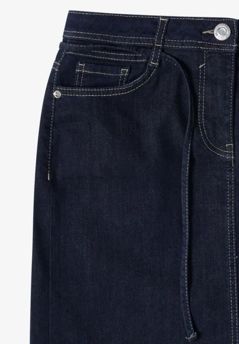 Jupe en jean arrivant aux genoux avec une ceinture rinsed wash Jean bleu foncé à taille élastique avec cordon, gros plan sur la ceinture et les poches.