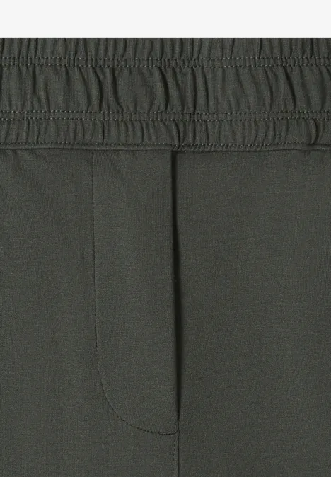 Gros plan d’un pantalon gris foncé avec taille élastique et couture centrale.