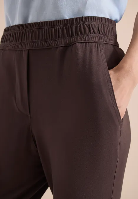 Pantalon marron décontracté à taille élastique et poches latérales, gros plan.