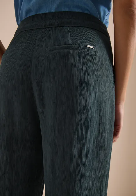 High Waist straight legs broek in Loose Fit palm breeze green Persoon van achteren in een zwarte, gestructureerde broek.