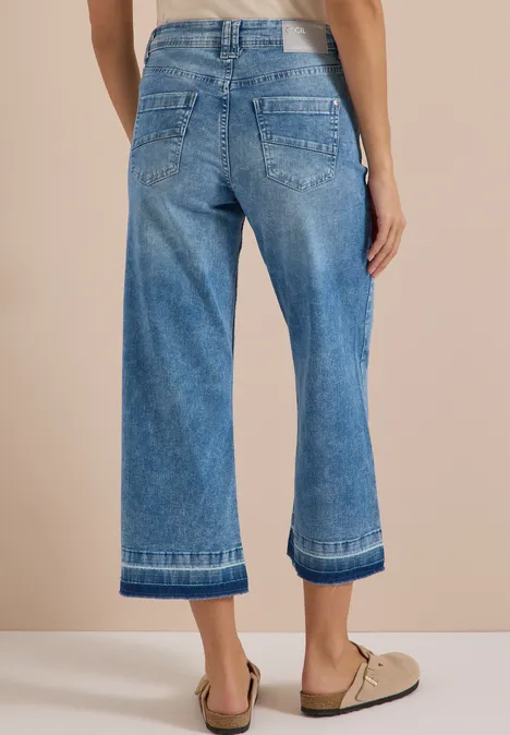 Straight Leg Jeans mit frasigem Saum light blue washed Rückansicht: Person in weiten, knöchellangen Jeans und beigen Loafern.
