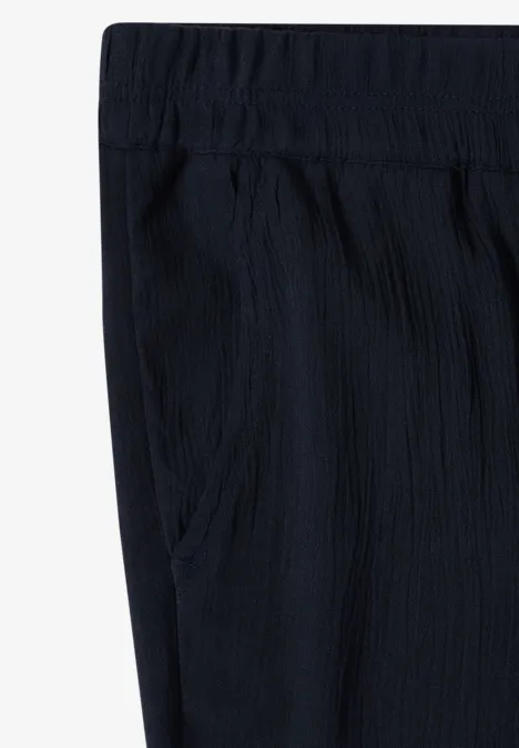 Schwarze, texturierte Hose mit elastischem Bund und seitlichen Taschen.