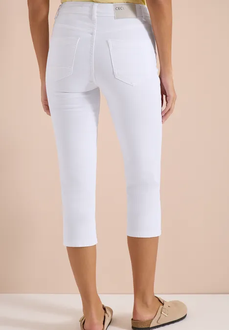 Witte capri-jeans met twee achterzakken, nauwsluitend, gecombineerd met beige loafers.