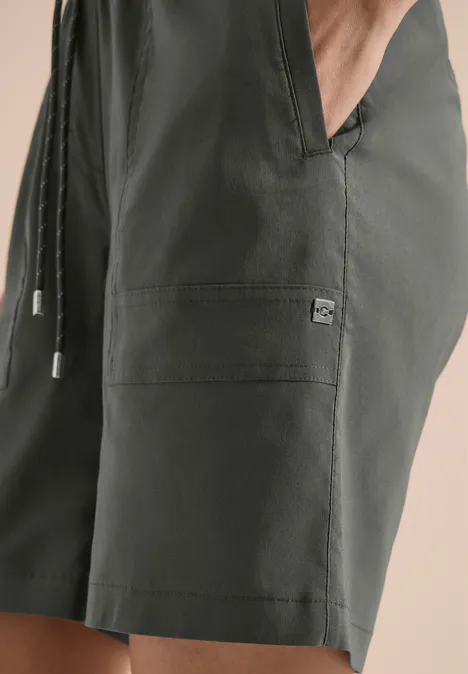 Dunkelgrüne Badehose mit Kordelzug und Seitentasche, knielang, aus leichtem Material.