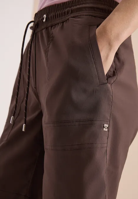 Braune Freizeit-Hose mit elastischem Bund, Kordelzug und seitlichen Taschen, lässig geschnitten.