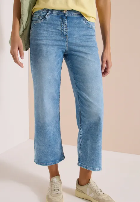Blauwe, wijde cropped jeans in middenblauw, nonchalante pasvorm met lichtgekleurde sneakers.