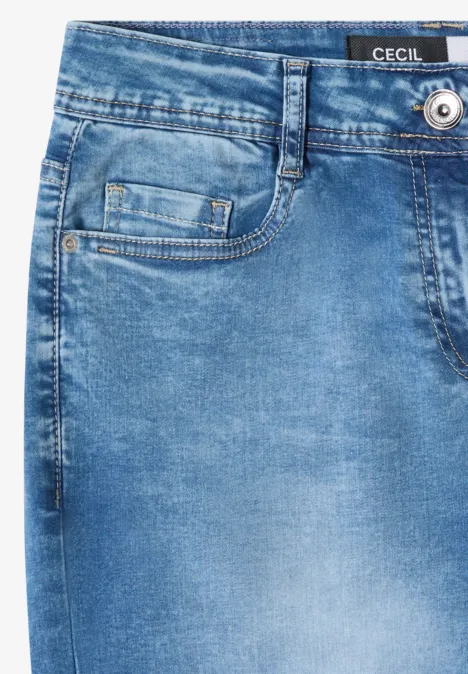 Close-up van een lichtblauwe spijkerbroek met zakken en 'CECIL'-label in de taille.