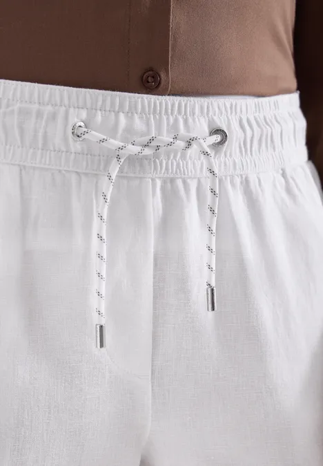 Makroaufnahme von weißen Leinenhosen mit elastischem Bund und Kordel.