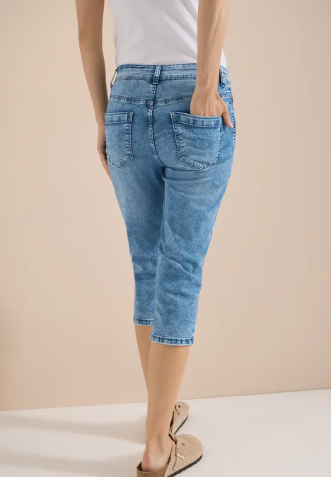 High waist Slim Fit Capri Jeans authentic used wash Person von hinten in hellblauer Capri-Jeans und beigen Espadrilles vor hellem Hintergrund.