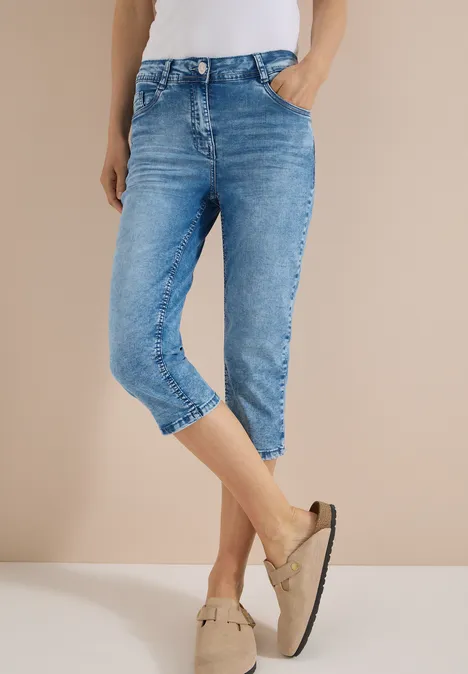 High waist Slim Fit Capri Jeans authentic used wash Eine Person trägt hellblaue Capri-Jeans und beige Mokassins.