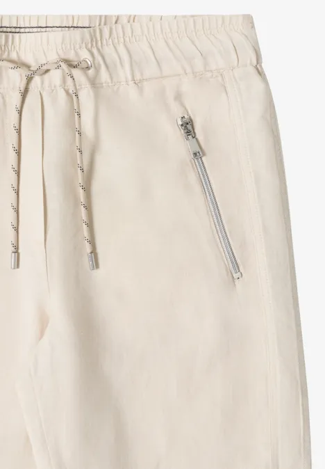 Pantalon clair en tissu léger avec taille élastique, cordon de serrage et poche zippée latérale.