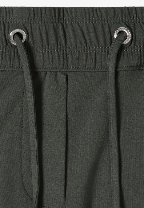 Donkergroene sweatbroek met elastische tailleband, koord met metalen ringen en zijzak.
