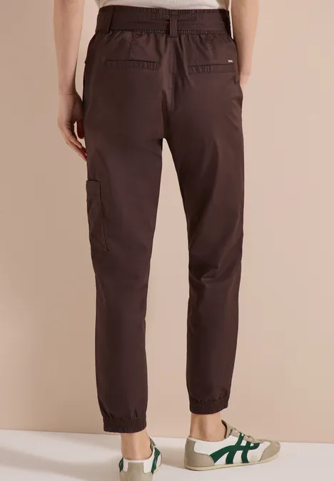 Rückansicht einer dunkelbraunen Cargo-Hose mit elastischem Saum, getragen zu weißen Sneakern.