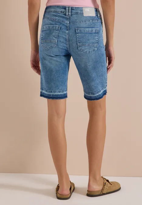 High Waist Wide Leg Jeans im Loose Fit light blue washed Rückansicht einer Person in lässigen Jeans-Bermudashorts und Sandalen.