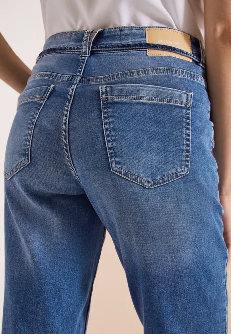 Nahaufnahme einer Person von hinten in blauen Jeans mit sichtbaren Gesäßtaschen.