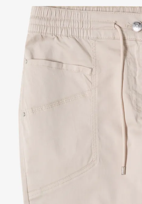 Beige Baumwollhose mit elastischem Bund, Kordelzug und seitlicher Tasche.