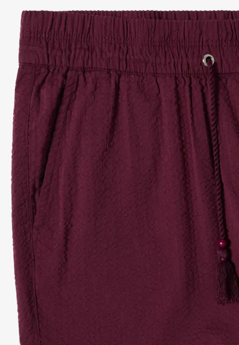 Bordeauxrode short van gestructureerde stof met elastische taille, steekzakken en koordsluiting met kwastje