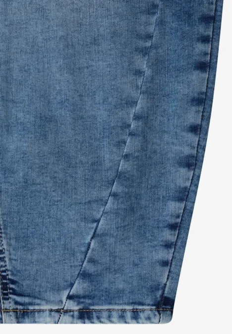 Detailaufnahme eines blauen Jeansbein-Endes mit sichtbarer Naht und Saum.