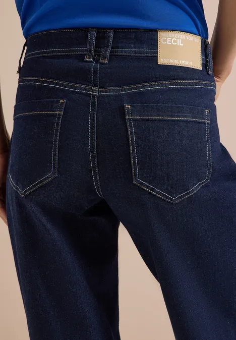 Rückansicht einer Person in dunklen Jeans mit sichtbarem Markenlabel am Bund