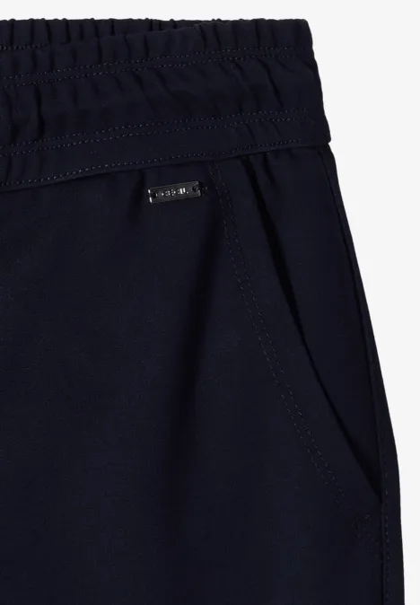 Donkerblauwe joggerbroek met elastische taille, zijzak en klein merkembleem.