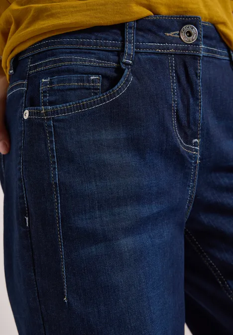 Nahaufnahme einer dunkelblauen Jeans mit Hosentaschen und sichtbarer Nahtgestaltung.