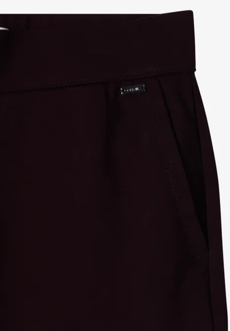 Detailaufnahme einer dunkelroten Jogginghose mit Eingriffstasche und kleinem Label