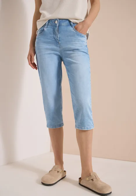 High Waist Slim Leg Jeans im Slim Fit light blue random bleached Helle, knöchellange Five-Pocket-Jeans im Capri-Stil mit geradem Schnitt, dazu beige Loafers.