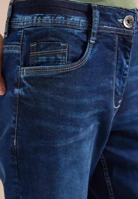 Detailaufnahme einer dunkelblauen Jeans mit Tasche und kontrastierenden Nähten.