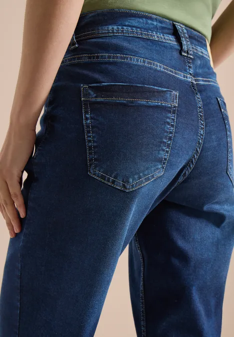 Rückenansicht einer Person in dunkelblauen Jeans mit sichtbaren Gesäßtaschen.