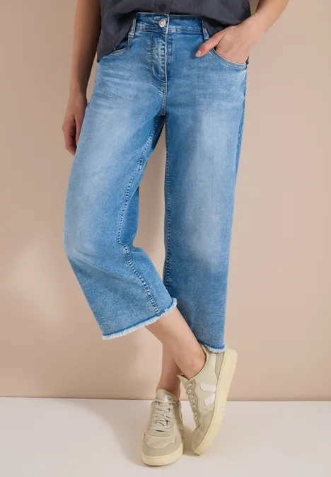 Helle, weite Jeans in Knöchellänge kombiniert mit hellen Sneaker.