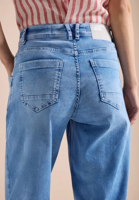 Rückansicht einer Person in hellblauen Jeans und rot-weiß gestreiftem Oberteil.