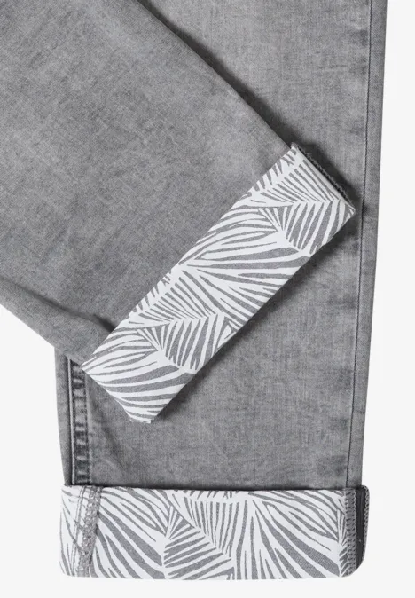 Graue Jeans mit umgeschlagenem Saum und weißem Blattmuster auf der Innenseite.