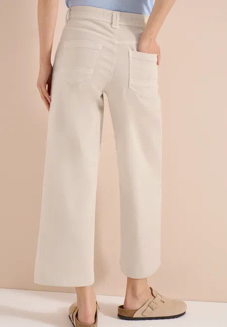 Beige Culotte-Hose mit hoher Taille und aufgesetzten Taschen, kombiniert mit beigen Clogs.