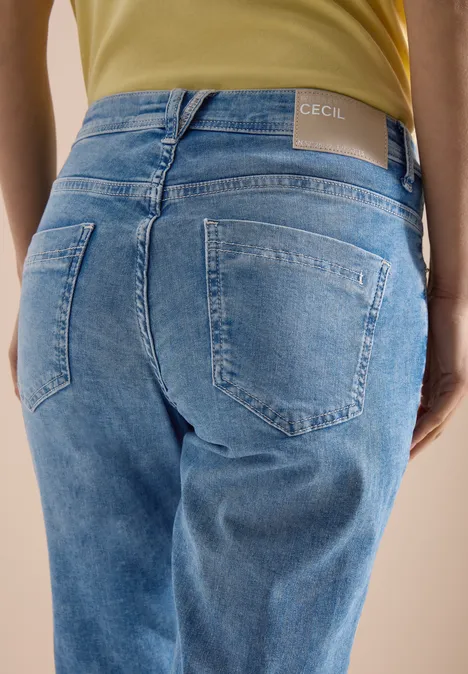 Achteraanzicht van een persoon in lichtblauwe jeans met merketiket in de taille.