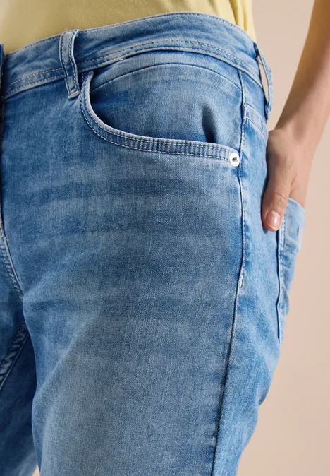 Close-up van lichtgewassen blauwe jeans met zakken en textuur.