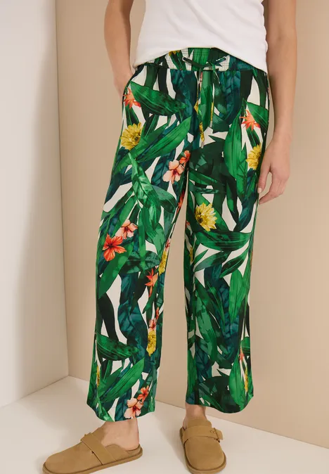 High Waist Wide Leg Hose im Loose Fit khaki Weite Hose mit grünem Dschungelprint und Blumen, kombiniert mit beigen Slippern.