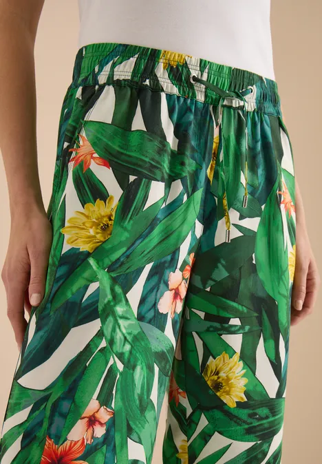 High Waist Wide Leg Hose im Loose Fit khaki Leichte, weite Sommerhose mit grünem Blatt- und gelbem Blumenprint und Taillenschnürung.