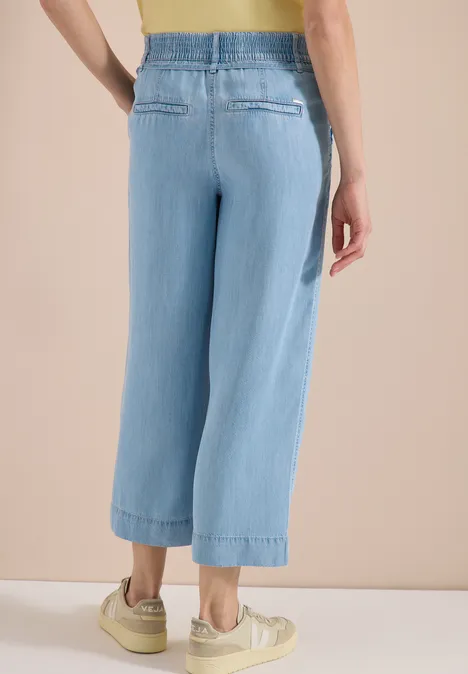 Helle, weit geschnittene Jeans mit elastischem Bund, knöchelkurz und lässigem Schnitt.