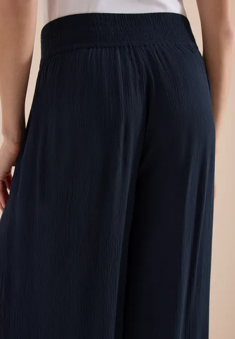 Pantalon ample et plissé de couleur foncée vu de dos