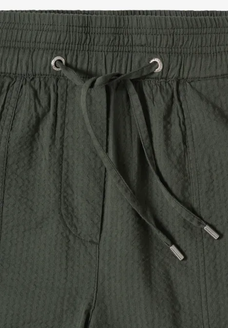 Dunkelgrüne, strukturierte Badeshorts mit elastischem Bund, Tunnelzug und vorderer Tasche.