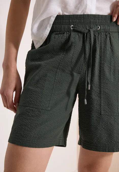 Dunkelgrüne, strukturierte Shorts mit elastischem Bund, Kordelzug und aufgesetzten Taschen.