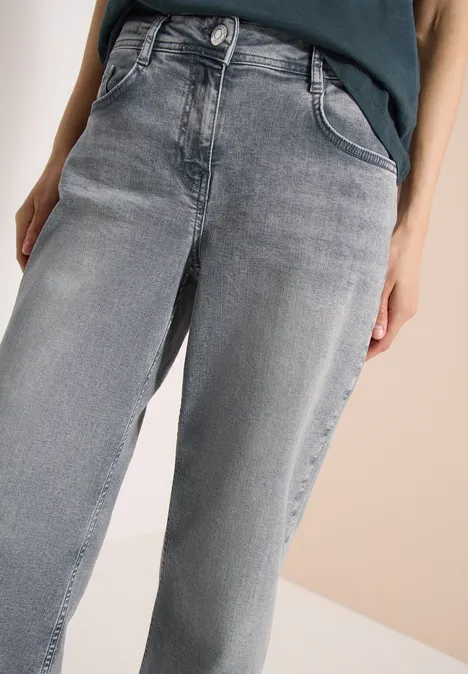 Grijze jeans met hoge taille en rechte pijpen, gecombineerd met een donker topje.
