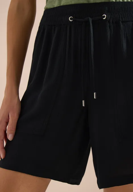 Schwarze, locker sitzende Shorts mit elastischem Bund und Kordelzug, seitliche Eingrifftaschen.