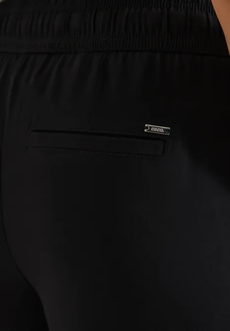 Schwarze Sporthose mit Reißverschlusstasche hinten und Markenlabel.