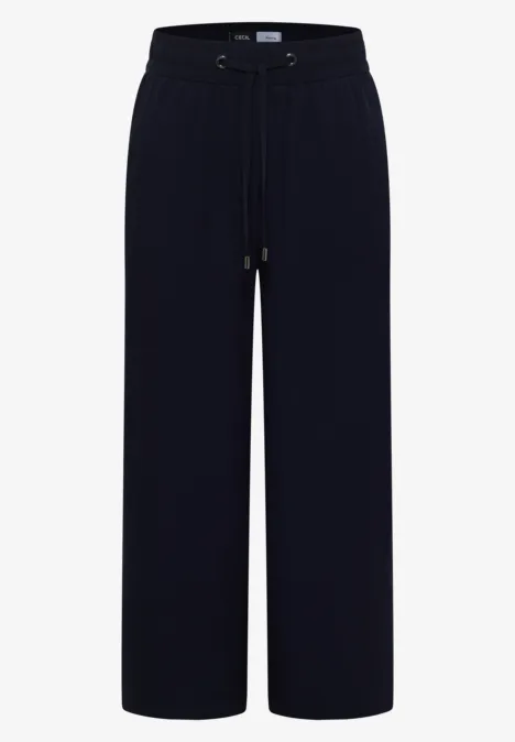Schwarze weite Hose mit hohem Bund und Kordelzug, fließendes Material, lange gerade Beine.